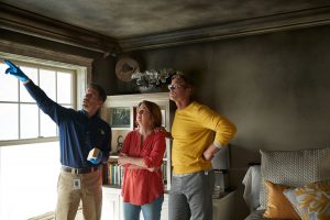 ServiceMaster technician pointing out fire damage inside a building