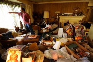Man looking at out the window of a hoarded home