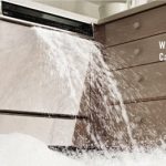 A dishwasher flooding a kitchen before water damage restoration services