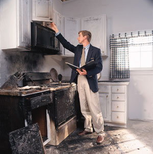 A ServiceMaster technician inspecting a kitchen affected by fire damage in New London, CT