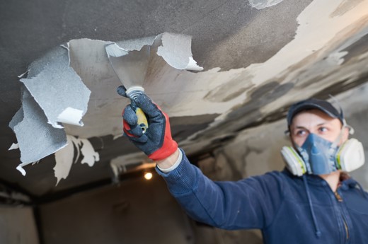 man restoring smoke damaged ceiling