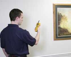 Man holding a device to the wall
