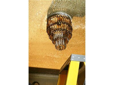A burned light fixture on a ceiling before fire restoration