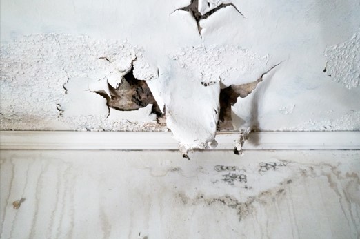 A water damaged ceiling and wall before water damage restoration