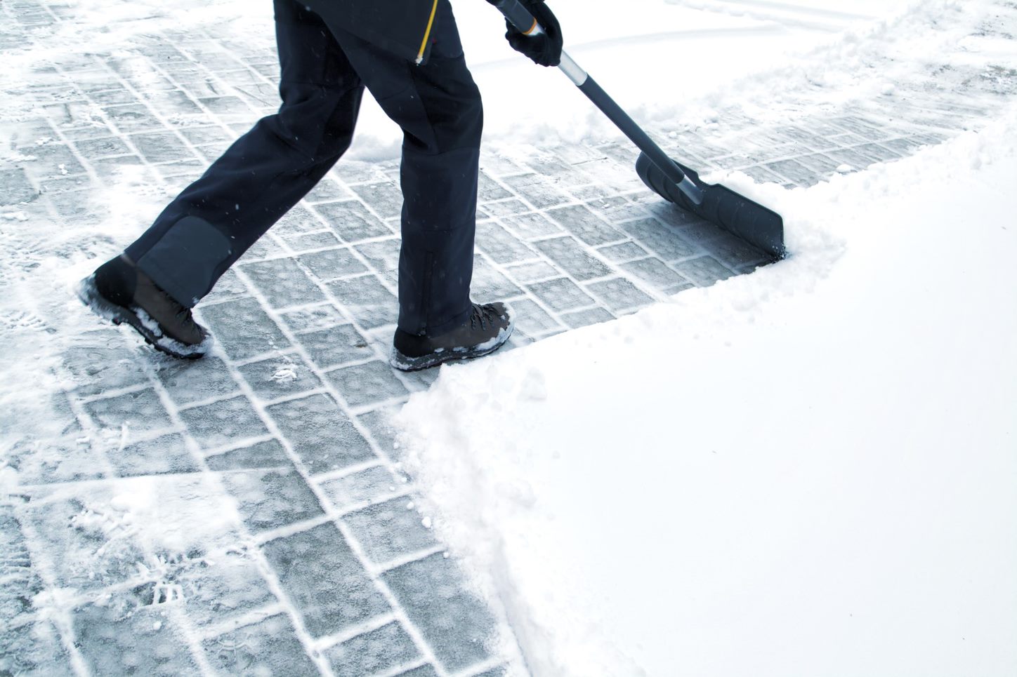 Man with shovel cleaning snow in the day light