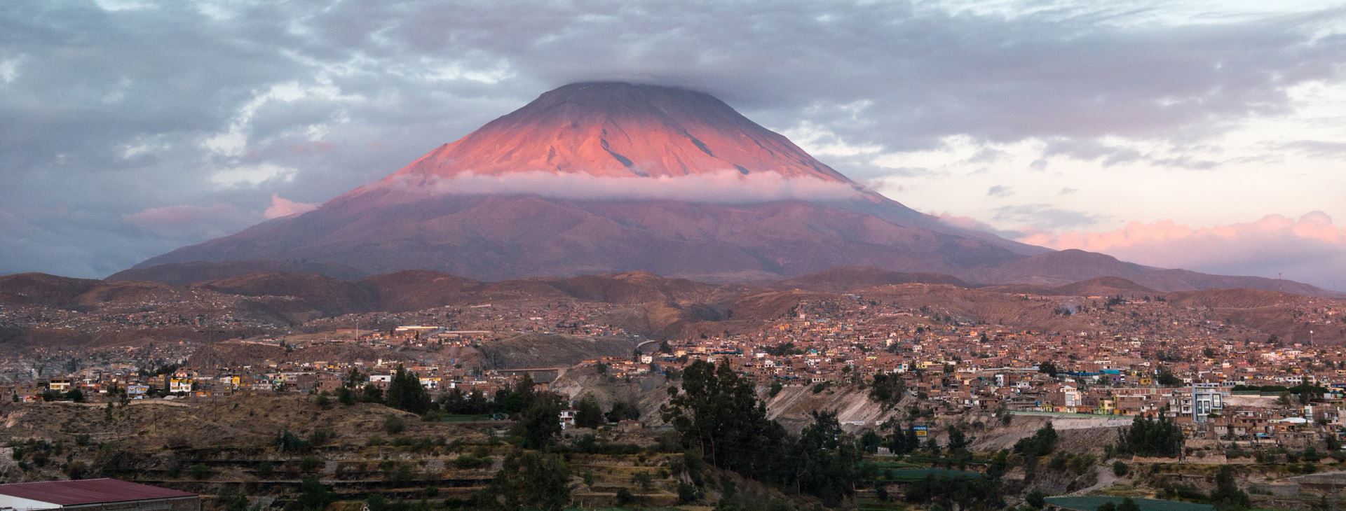 A volcano looking over a city
