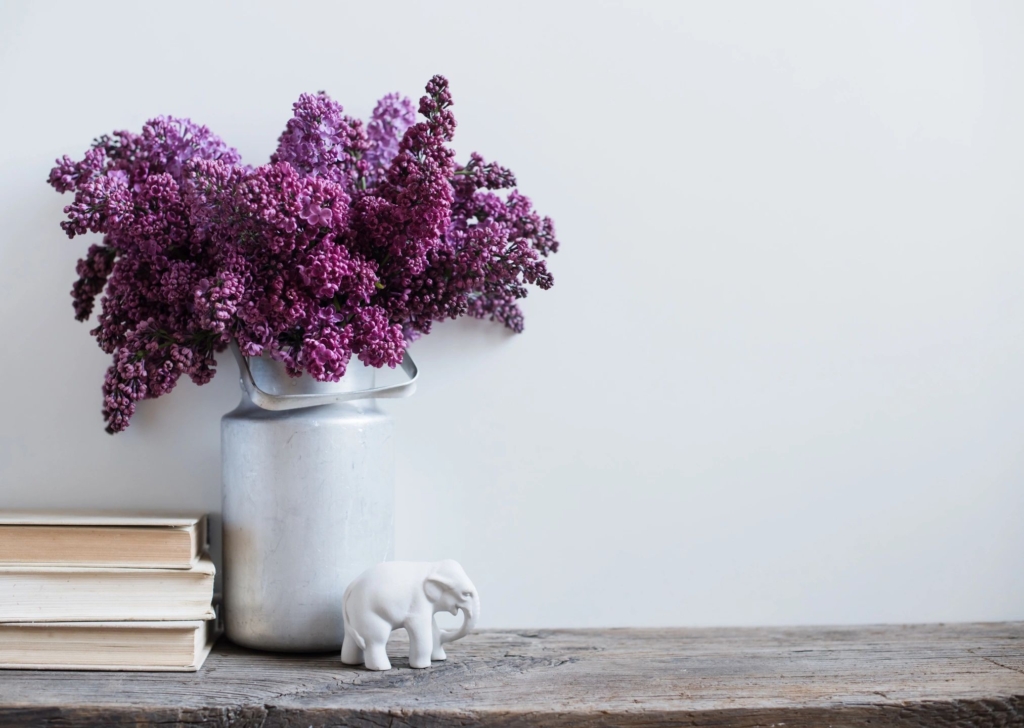 a plant in a flower pot and a elephant with book on a table.