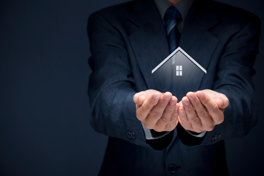 A person holding a house in two hands