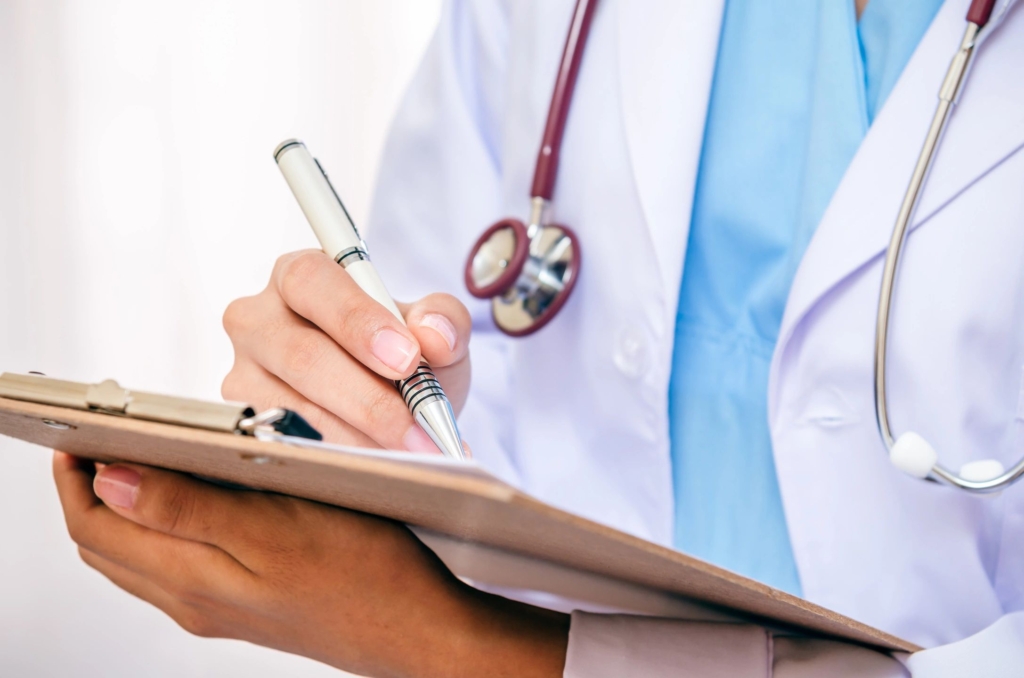 Doctor writing on a note pad