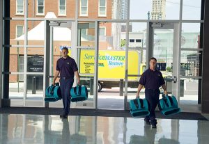 Men walking into building with restoration fans