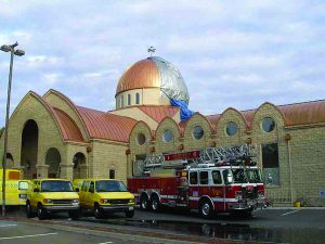 Church being restored with a firetruck in front and yellow trucks