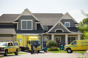 Servicemaster trucks in front of a home