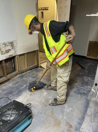 water damage technician cleaning floors
