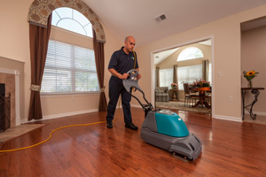 Man cleaning a wood floor. 