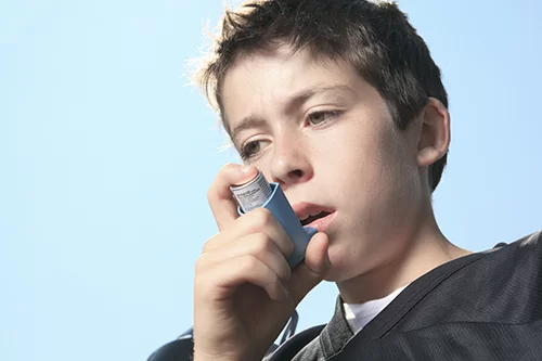 little boy using an inhaler