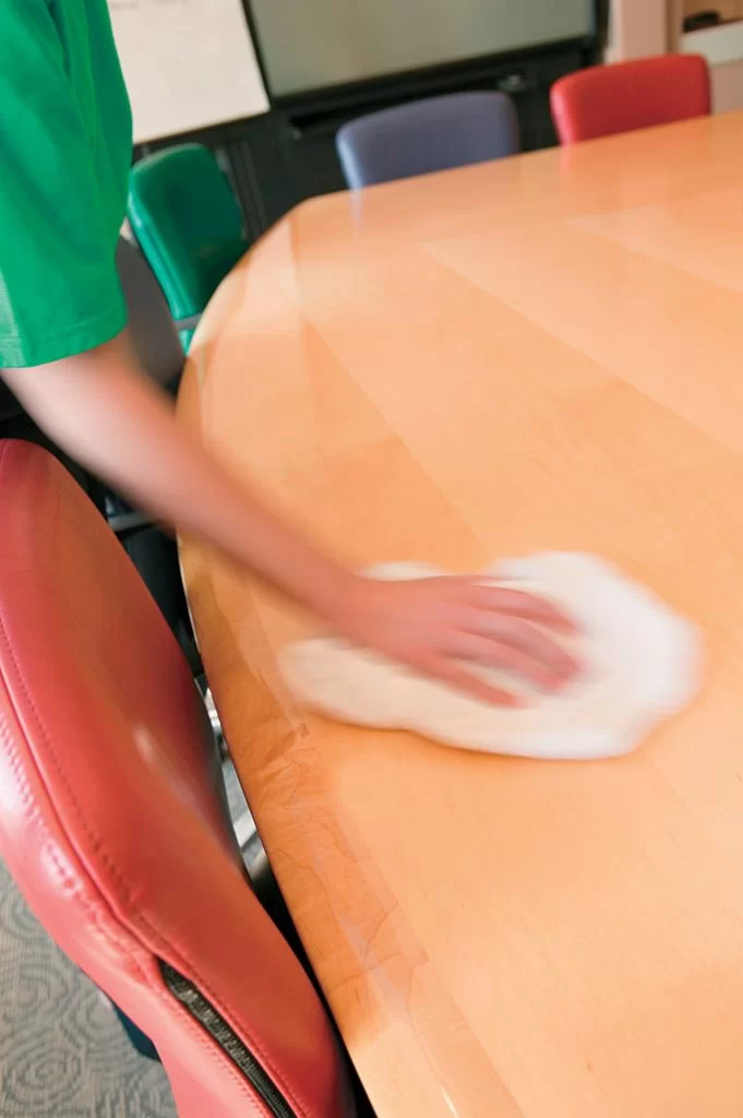 person wiping down a table