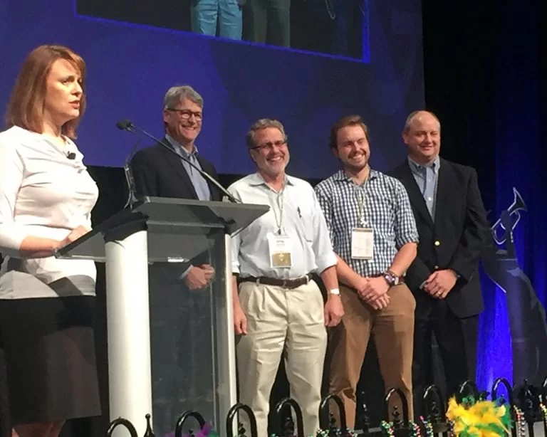 Greg and Charles Gandee on the stage receiving recognition for 30 years in business