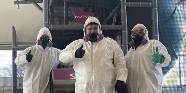 three servicemaster professionals in protective hazmat suits