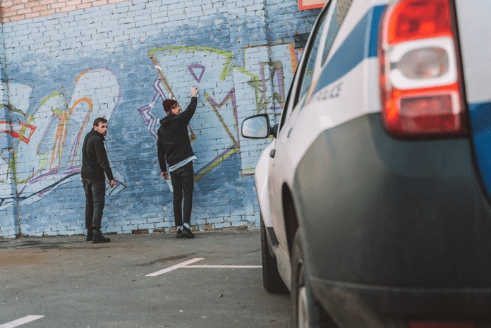 people vandalizing wall