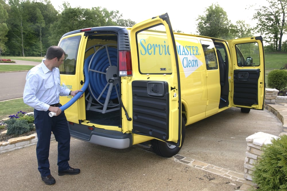 ServiceMaster technician taking a hose out of company van for sewage cleanup