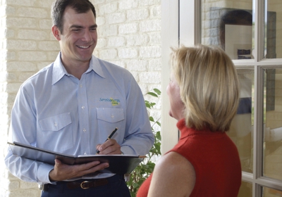 ServiceMaster Restore sewage cleanup technician taking notes while listening to a homeowner