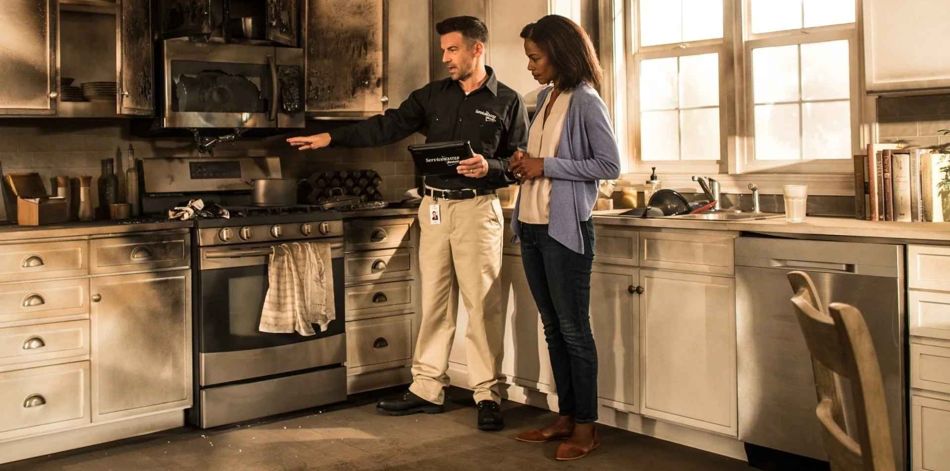 A man and woman discussing fire accident in the kitchen