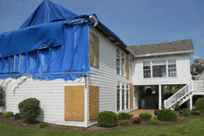 A house covered in tarp and boarded up before fire damage restoration services in Collinsville