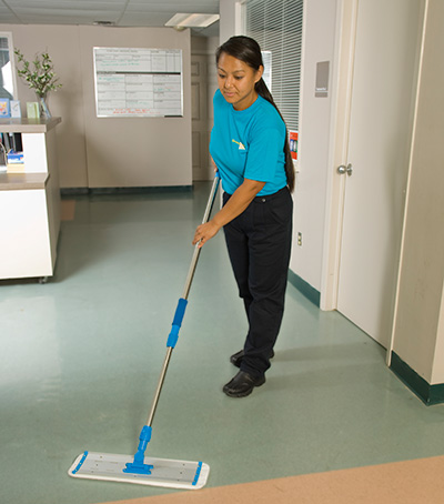 servicemaster team member mopping floor of healthcare facility
