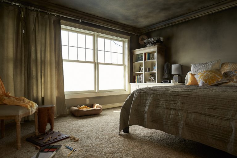 fire damaged bedroom with soot covering walls and curtains