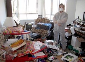 Man standing in the middle of a cluttered room