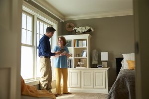 A ServiceMaster technician standing with a client in her newly cleaned bedroom after hoarding cleaning services