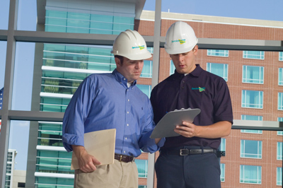 Two Construction Workers Looking at Clipboards