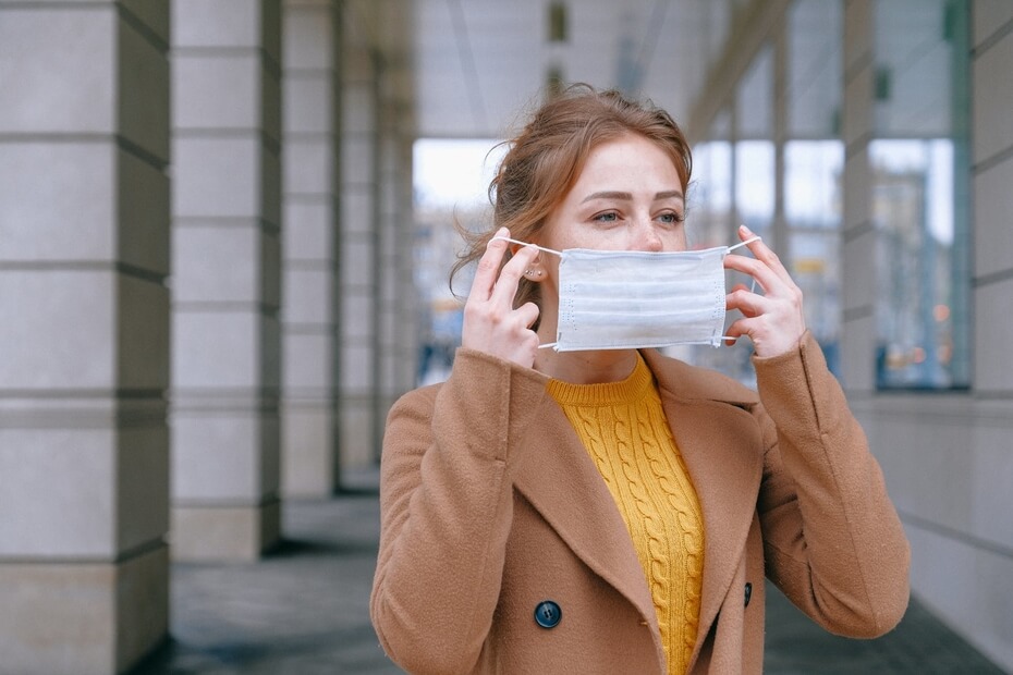 Woman Putting Face Mask On