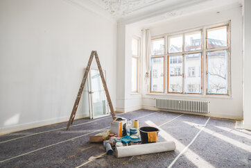 Empty Room with Ladder and Cleaning Supplies on Floor