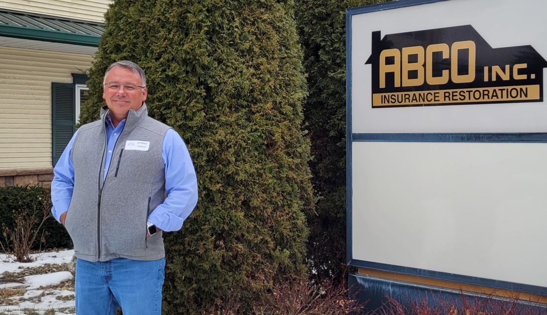 Jeremy Davidson standing next to ABCO Inc Insurance Restoration Sign
