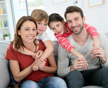 Family of Four Sitting Together on Couch after professional cleaning services in South Bend