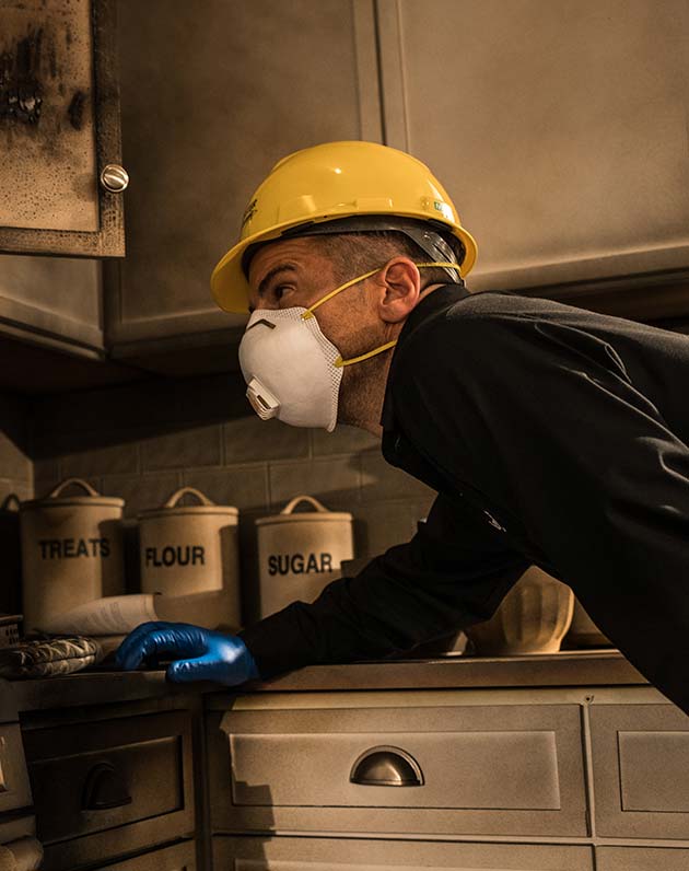 A ServiceMaster technician inspecting a kitchen during fire odor removal services
