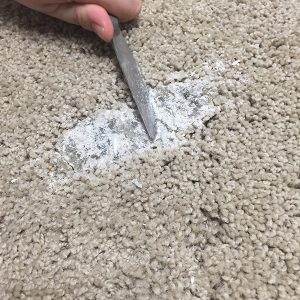 scraping candle wax off carpet with butter knife