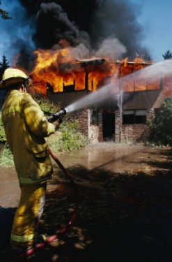 Fireman Using Water Hose on House Fire