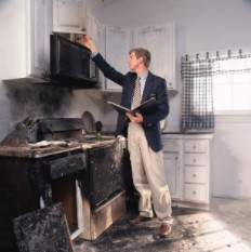 Man Assessing Fire Damage in Kitchen