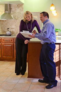 Man holding pen and clipboard explaining to a blonde woman for house construction and remodeling