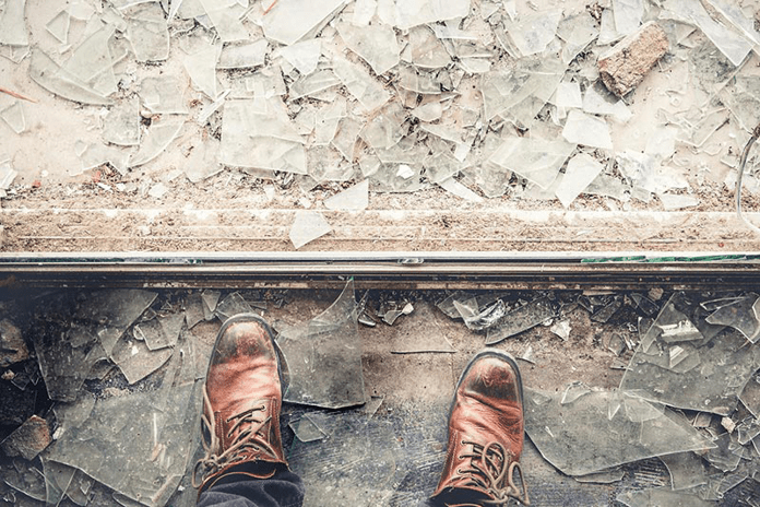 A person standing in broken glass