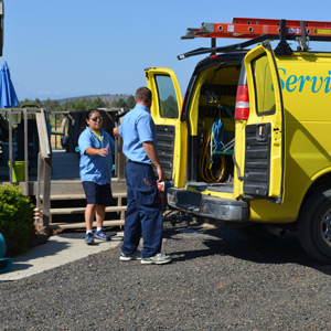 Two ServiceMaster technicians grabbing equipment from a ServiceMaster branded van before beginning a fire damage restoration service