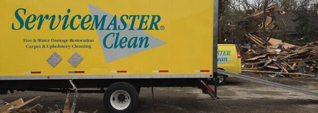 ServiceMaster truck in front of tornado damage. 